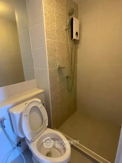 Modern bathroom with shower and toilet in a sleek tiled design.