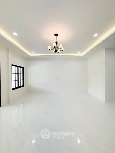 Spacious modern living room with elegant chandelier and large windows