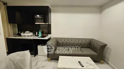 Modern living room with sleek black kitchen and elegant gray sofa