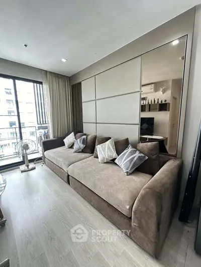 Modern living room with large sofa and balcony view in stylish apartment