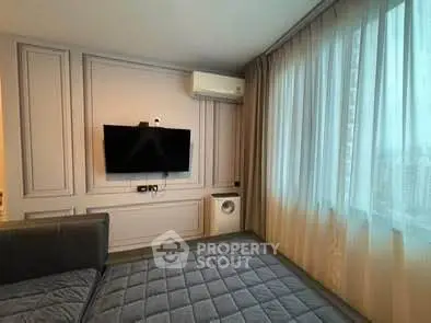 Modern bedroom with TV and large window in stylish apartment