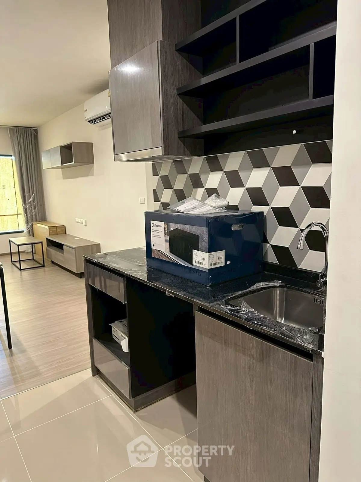 Modern kitchen with sleek cabinetry and geometric backsplash in a contemporary apartment.