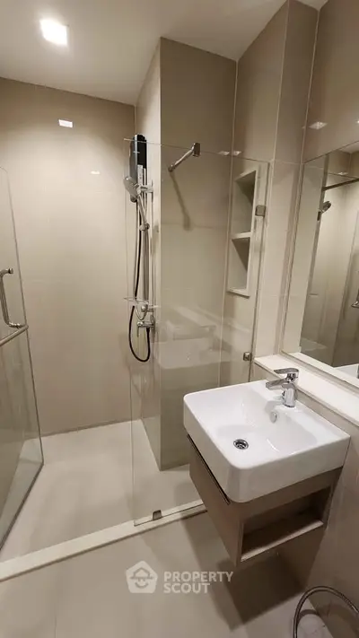 Modern bathroom with sleek shower and stylish sink in contemporary apartment.