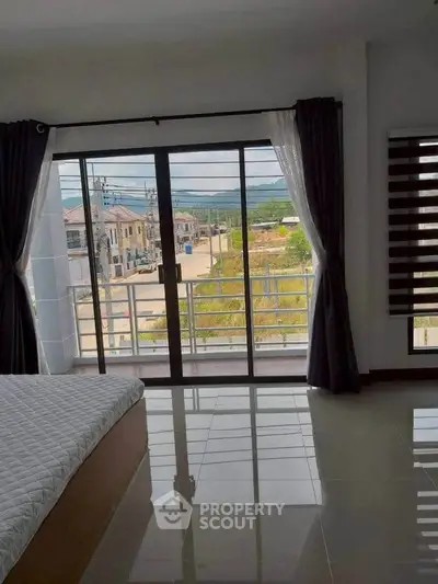 Spacious bedroom with balcony and scenic view in modern home