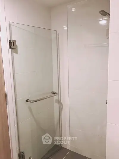 Modern bathroom with glass shower enclosure and sleek tile design.
