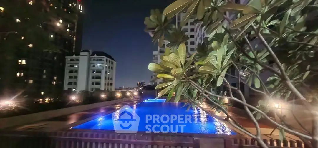 Luxurious night view of illuminated swimming pool in upscale residential complex.