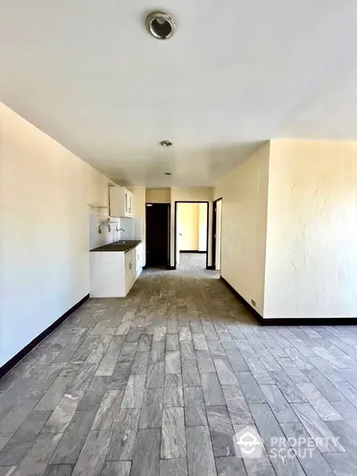 Spacious open-plan living area with modern kitchen and tiled flooring