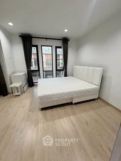 Spacious modern bedroom with large windows and elegant decor