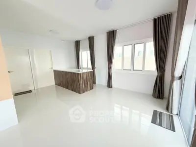 Spacious modern living room with large windows and elegant curtains