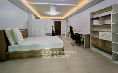 Spacious modern bedroom with sleek furniture and ample storage space.