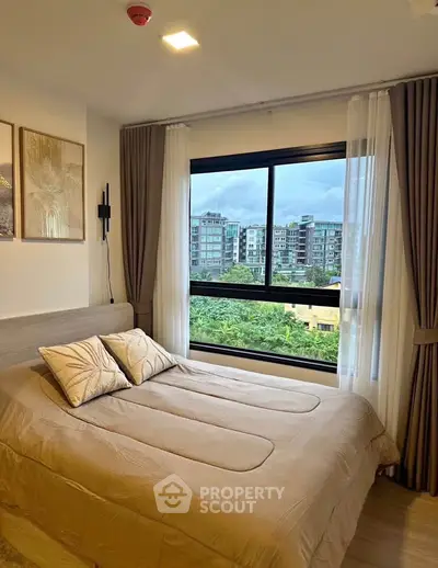 Cozy bedroom with large window offering a stunning city view, elegant decor, and modern furnishings.