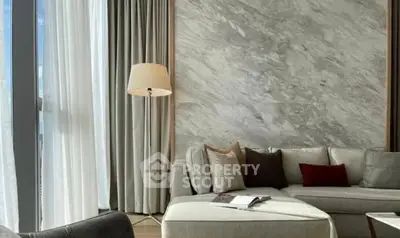 Luxurious living room with elegant sofa and floor lamp, featuring a stylish marble accent wall.