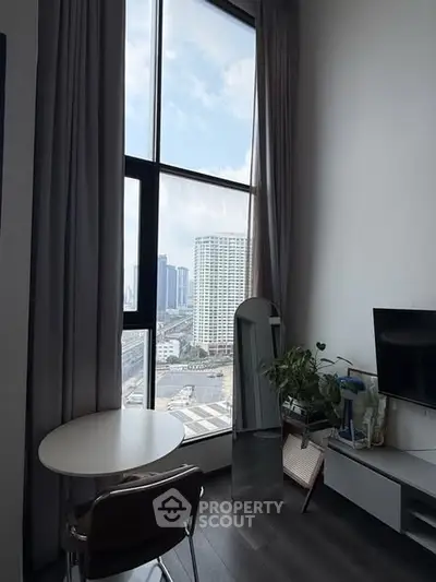 Modern living room with floor-to-ceiling windows offering stunning city views, sleek furniture, and elegant decor.