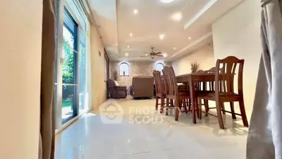 Spacious dining and living area with elegant wooden furniture and bright natural lighting.