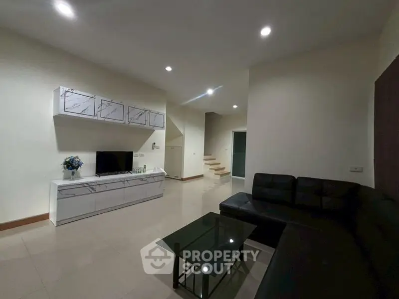 Spacious modern living room with sleek black sofa and stylish decor