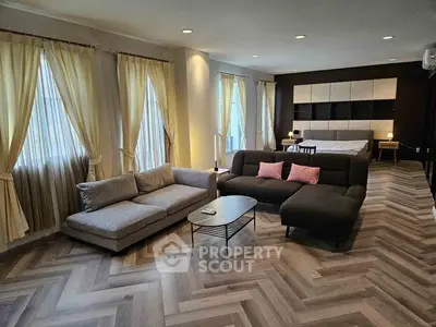 Spacious modern living room with elegant herringbone flooring and cozy seating area.