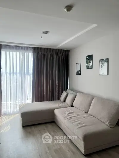 Modern living room with large sofa and floor-to-ceiling window for natural light
