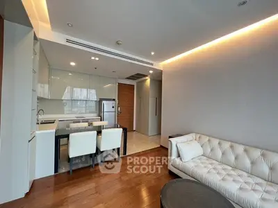 Modern open-plan living room with sleek kitchen and elegant dining area in luxury apartment.