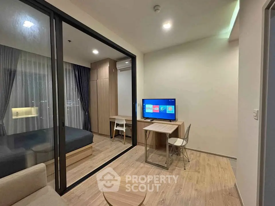 Modern studio apartment with open layout, featuring a cozy living area and sleek furnishings.