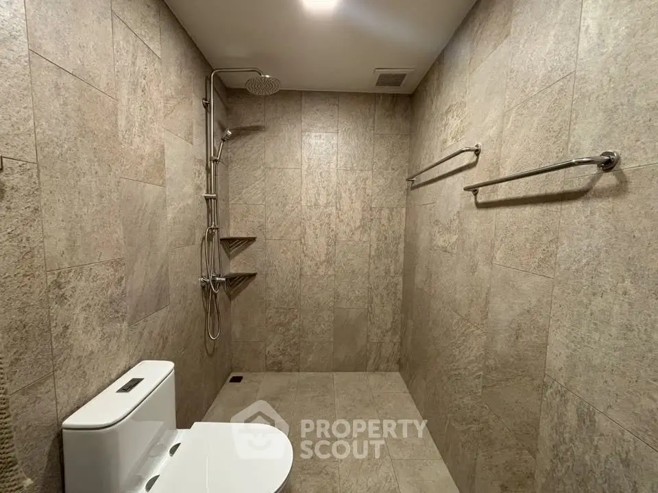 Modern bathroom with stone tiles and sleek shower design