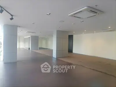 Spacious commercial interior with modern ceiling design and ample natural light.