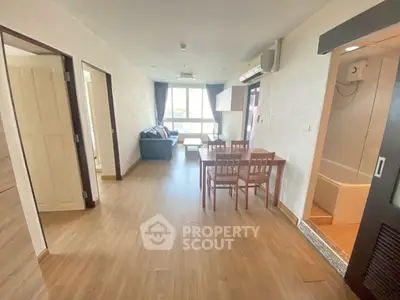 Spacious open-plan living and dining area with wooden flooring and natural light.