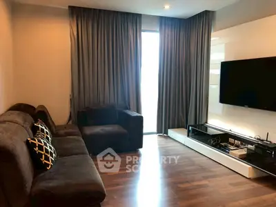 Modern living room with sleek furniture and large TV, perfect for relaxation and entertainment.