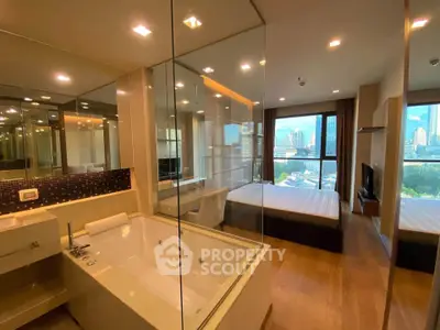 Luxurious condo with glass-walled bathroom and stunning city view from the bedroom.