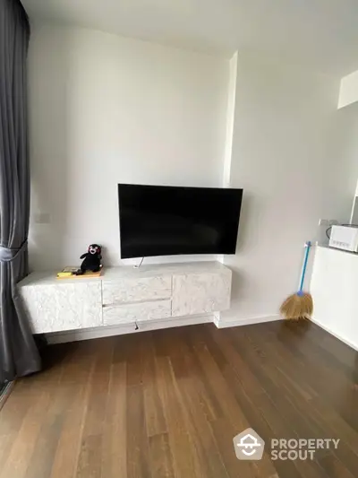 Modern living room with wall-mounted TV and stylish wooden flooring