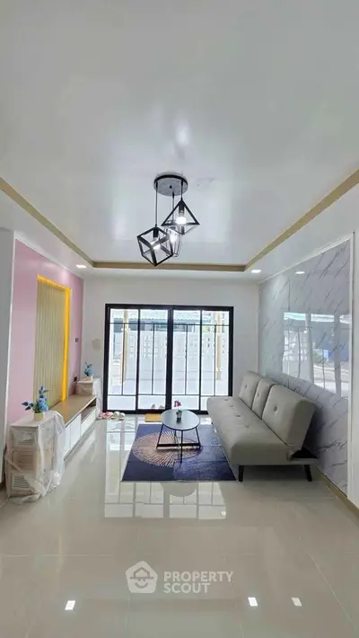 Modern living room with stylish lighting and large windows offering natural light.