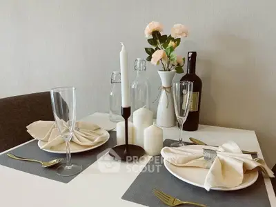 Elegant dining setup with candles and flowers on a modern table, perfect for intimate gatherings.