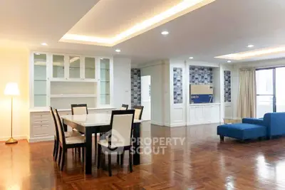 Spacious open-plan living and dining area with elegant lighting and modern furnishings.