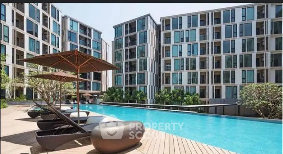 Luxurious modern apartment complex with stunning pool and sun loungers