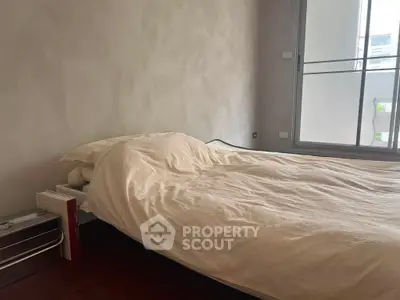 Cozy bedroom with large window and minimalist decor, perfect for relaxation and comfort.