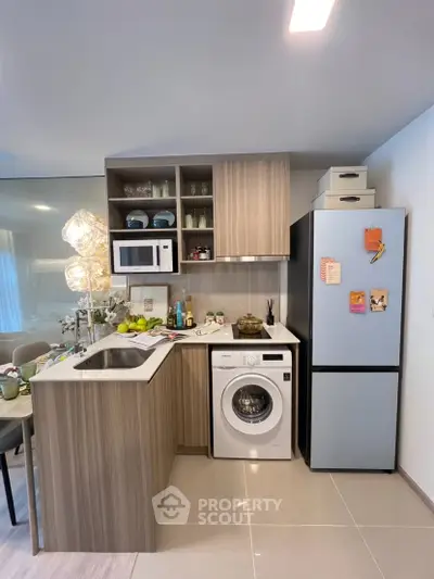 Modern kitchen with sleek cabinetry, built-in microwave, washing machine, and stylish decor.