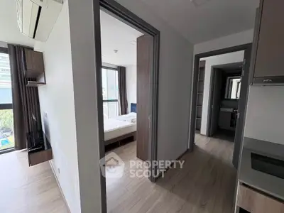 Modern apartment interior with bedroom and hallway, featuring sleek design and natural light.
