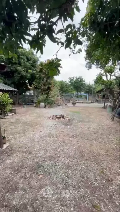 Spacious garden area with lush trees, perfect for outdoor activities and relaxation.
