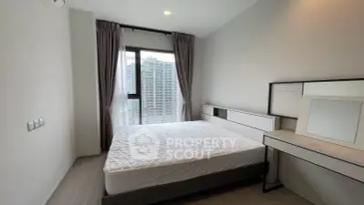 Modern bedroom with large window and city view in high-rise apartment