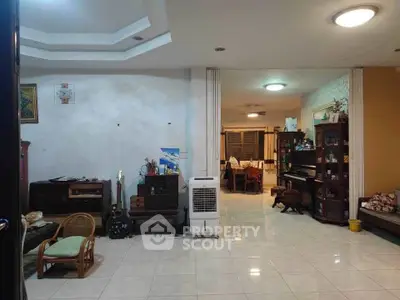 Spacious living room with open layout and elegant decor, featuring a piano and modern lighting.