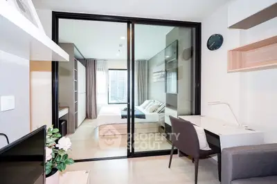 Modern bedroom with glass partition and stylish workspace in a contemporary apartment.