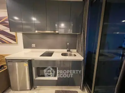 Modern compact kitchen with sleek cabinetry and built-in appliances in a stylish apartment.