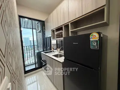 Modern kitchen with sleek cabinetry and balcony view in urban apartment