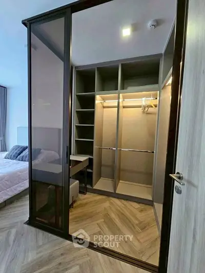 Spacious walk-in closet with modern design adjacent to a cozy bedroom.