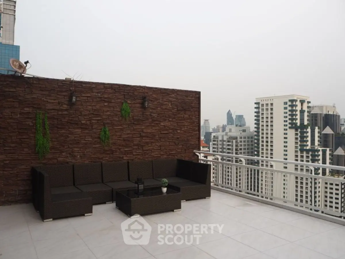 Spacious rooftop terrace with city skyline view and modern seating area.
