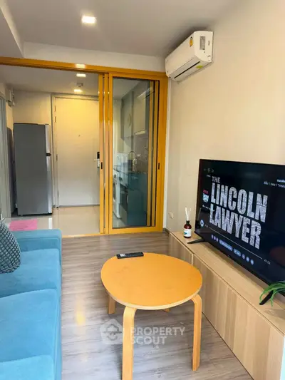 Modern living room with blue sofa, wooden table, and TV in stylish apartment