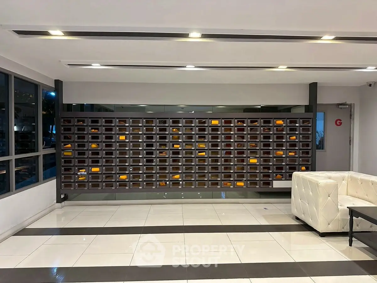 Modern apartment building lobby with stylish seating and mailboxes.