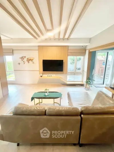 Spacious modern living room with stylish decor and large windows offering natural light and garden view.
