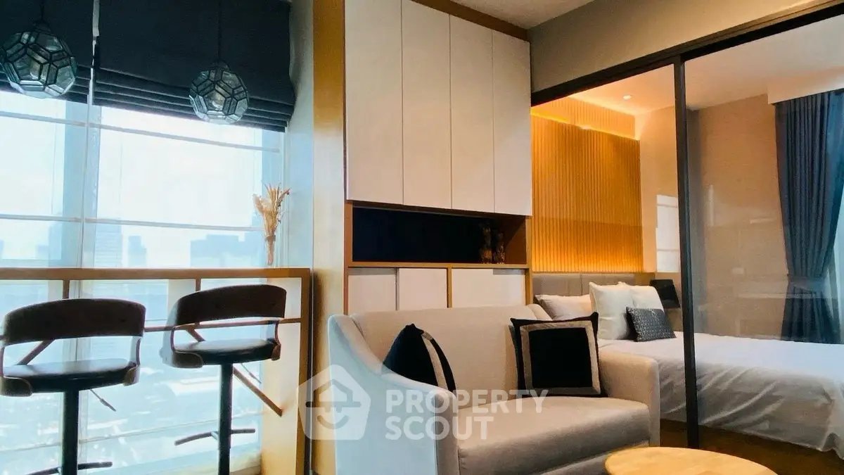 Modern apartment interior with stylish living room and bedroom, featuring large windows and elegant decor.