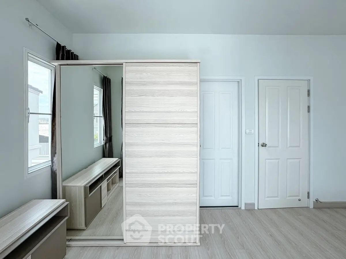 Spacious bedroom with modern wardrobe and natural light