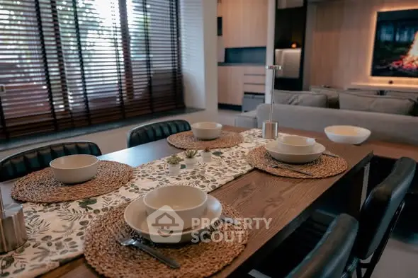 Modern dining area with stylish table setting and cozy living room view.
